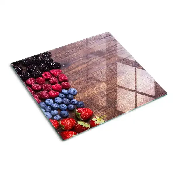 Tabla de cortar de cristal Frutos del bosque sobre un fondo de madera